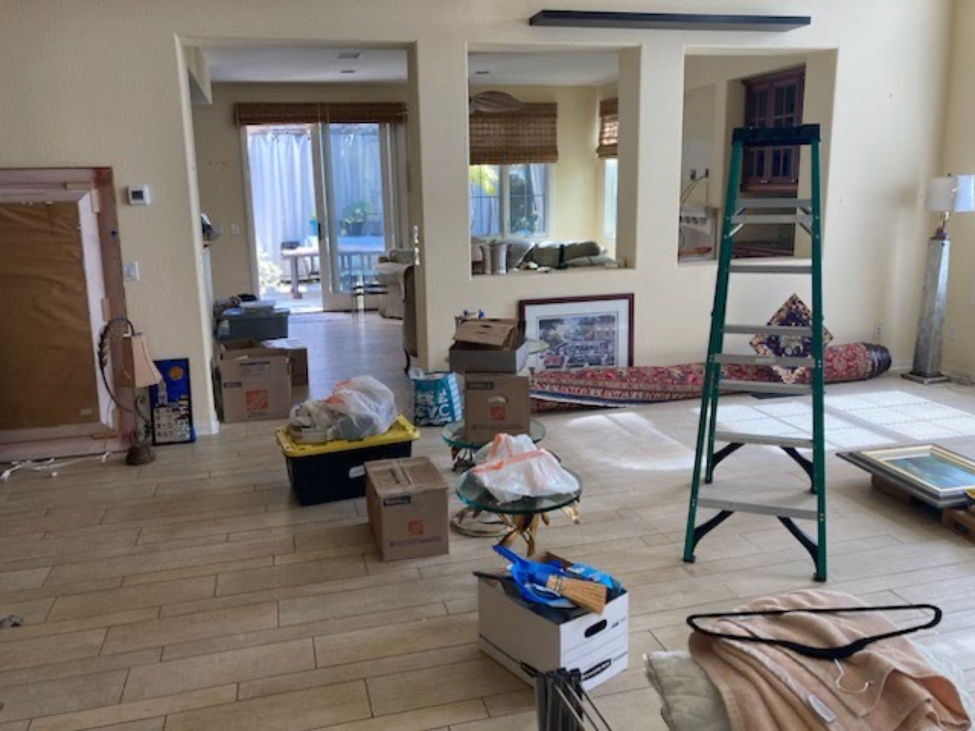 Living room mid-cleanout — boxes, art, and a ladder staged for JunkMD+ estate cleanout in San Diego